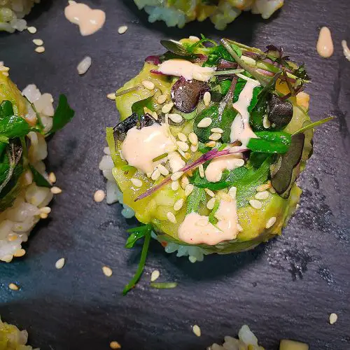 spicy mayo and sesame seeds garnish sushi stacks