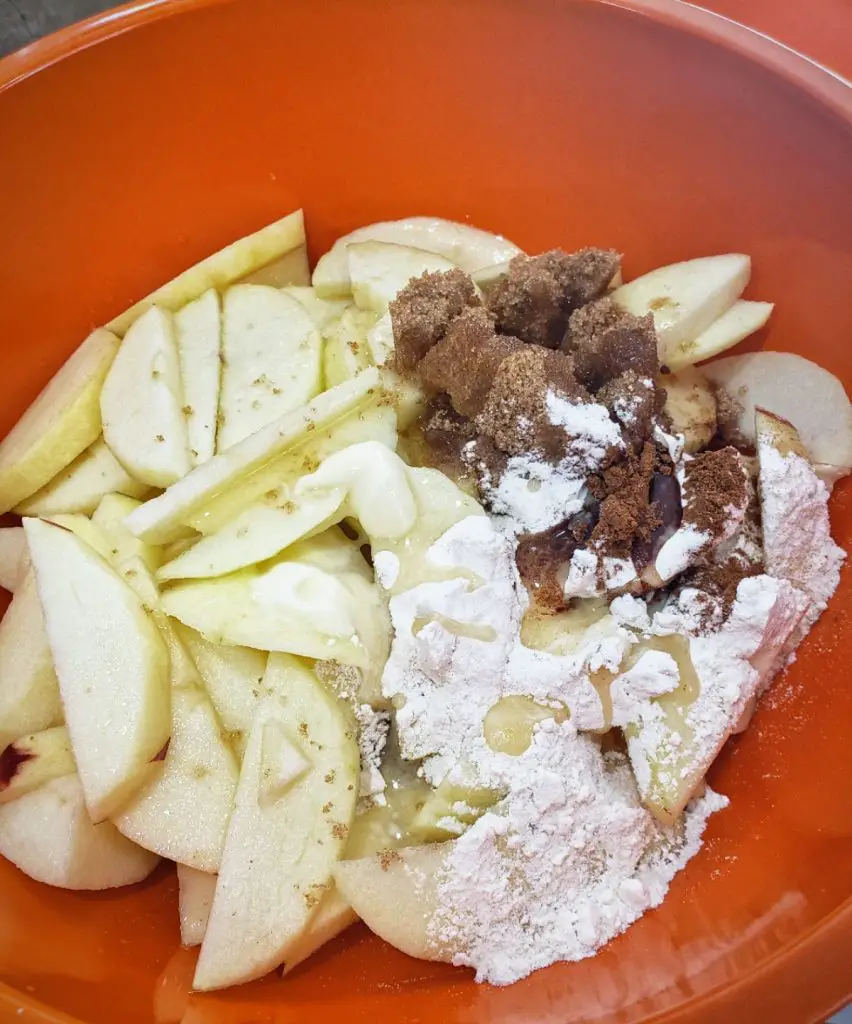 apple slices coated with brown sugar, cinnamon and flour for apple crisp