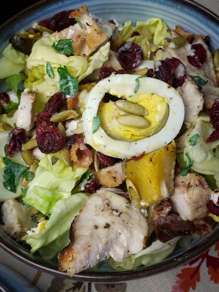 harvest cobb salad in small bowl and dressing on top