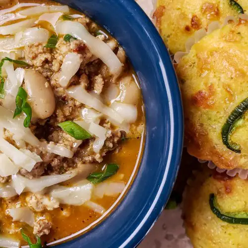 white bean turkey chili in blue bowl served with cornbread