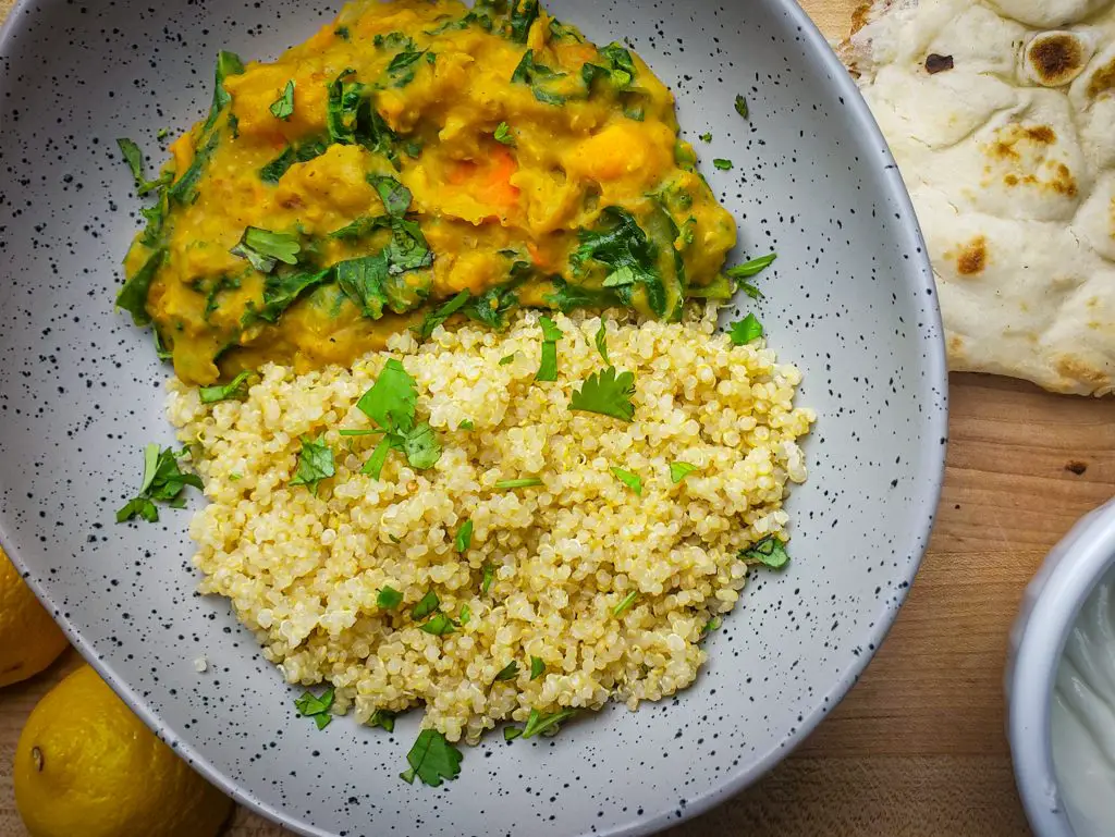 instant pot sweet potato red lentil coconut curry served with a side of quinoa and naan bread
