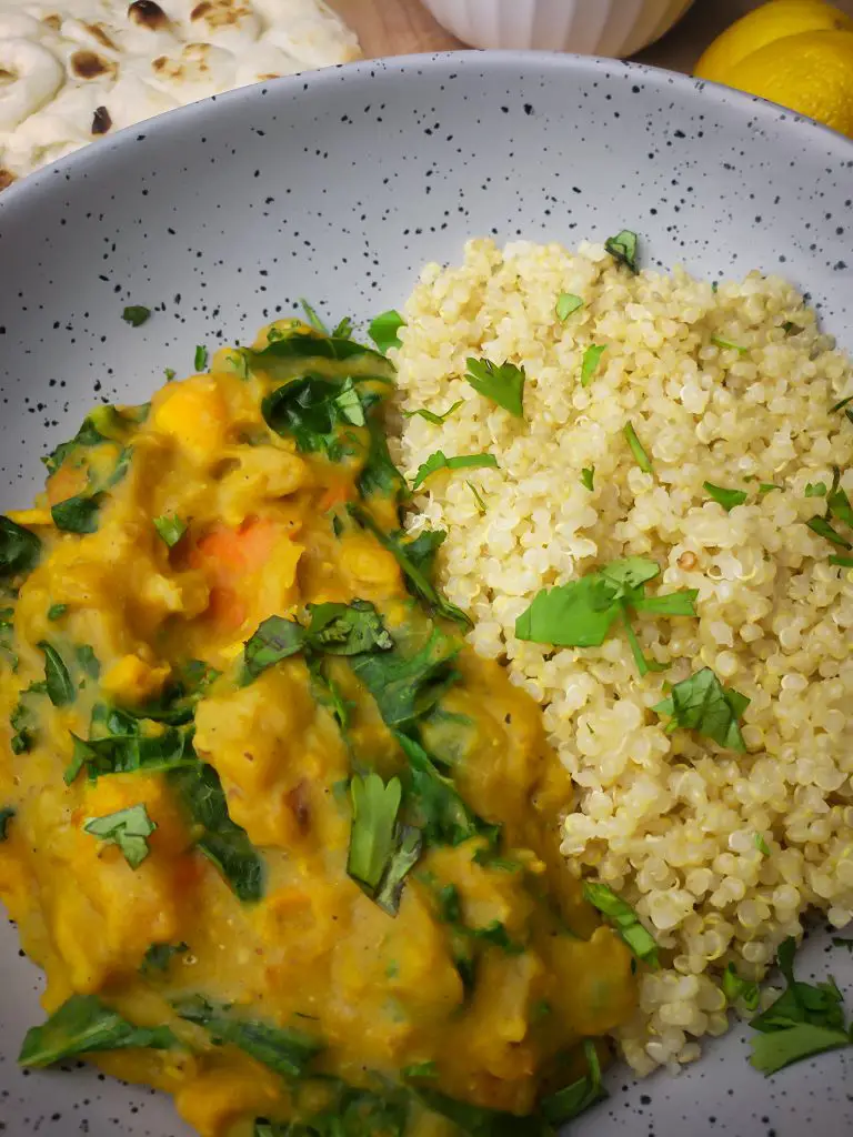 instant pot sweet potato red lentil coconut curry served with a side of quinoa