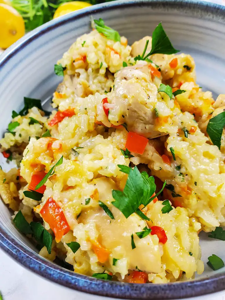 image of bowl of cheesy chicken and rice garnished with parsley