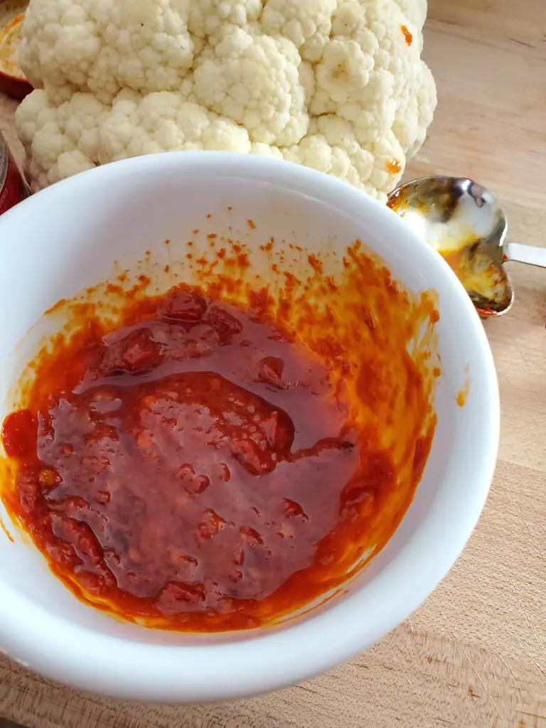 image of cauliflower next to harissa paste and olive oil mixture