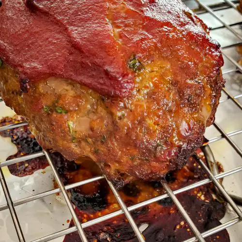 Imagen de cerca de un mini pastel de carne glaseado con salsa de tomate en la bandeja del horno hoja de hornear