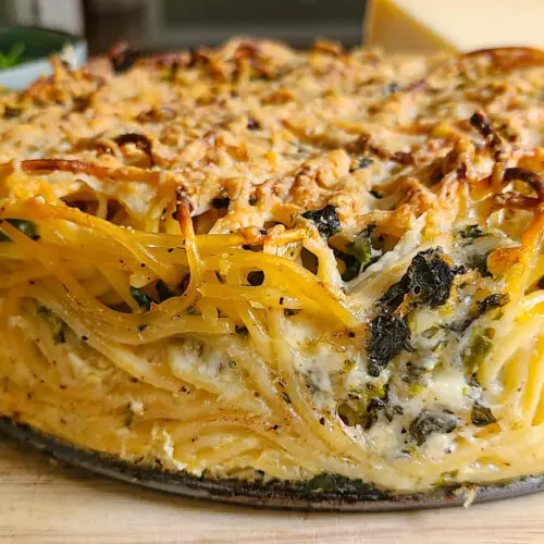 side angle upclose image of spaghetti frittata pie with a crunchy browned top and sides